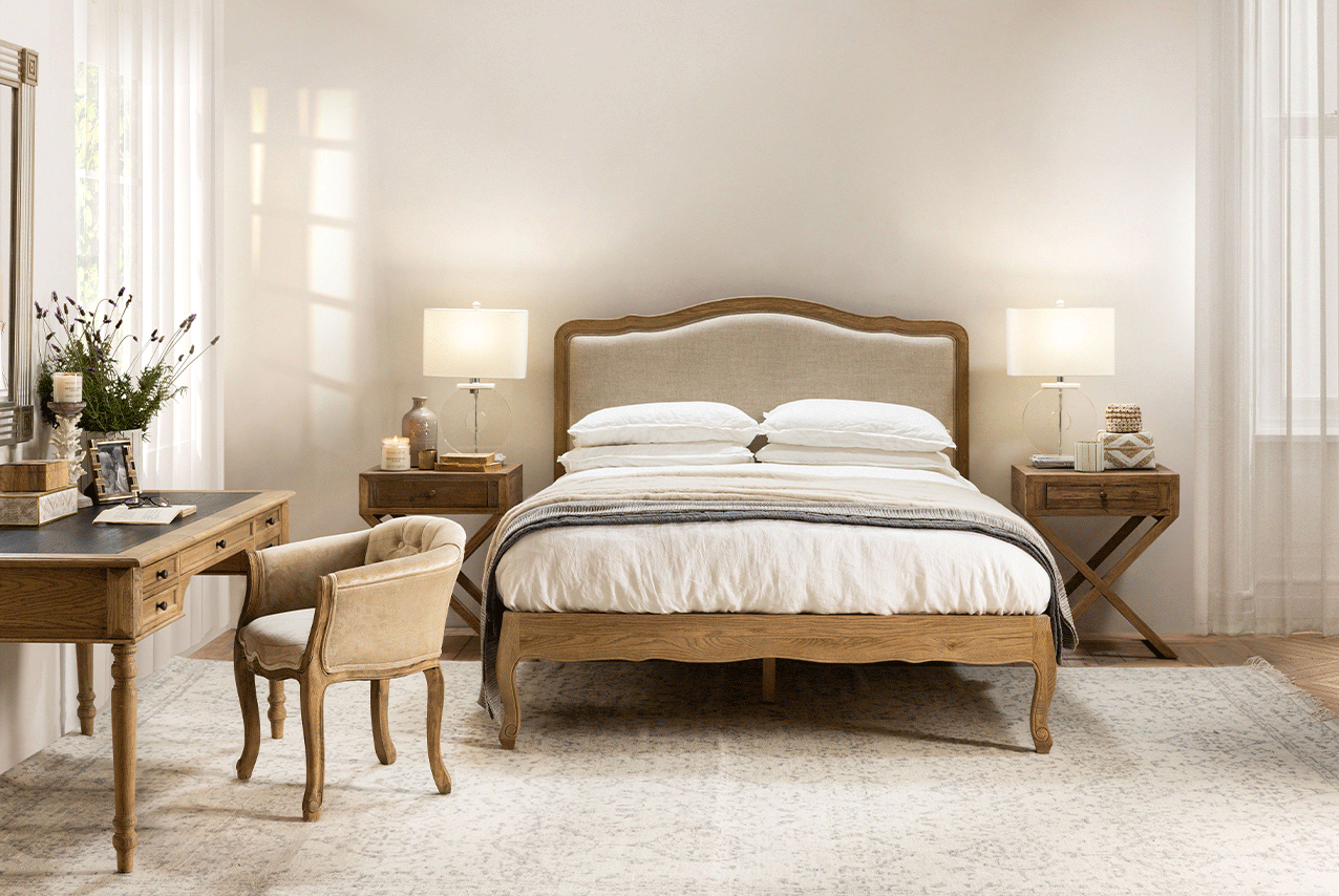 French boudoir style with upholstered headboard and natural wood bed